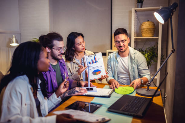 istock A group of four young people is sitting together at home, collaborating on a project using a laptop, with focused and engaged expressions. 2157166093