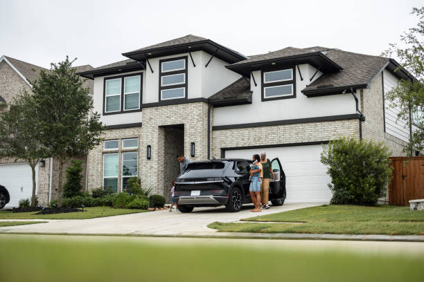 Multiethnic Family Charging EV Car with Solar Panels on Roof