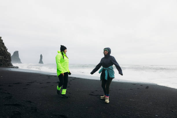 istock Two Happy Tourists Feeling Freedom Together at Idyllic Black Sand Beach 2157167890