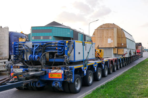 Very long specialized multi axle truck trailer carries very heavy oversize transmission network static synchronous compensator, rear view