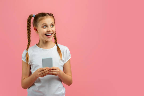istock Girl holding phone, excited by content on pink 2157171178