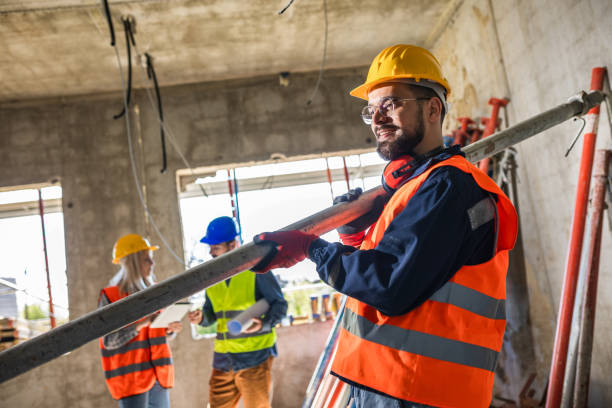 istock Two construction workers carrying a scaffolding at a building site - people at work concepts 2157172008