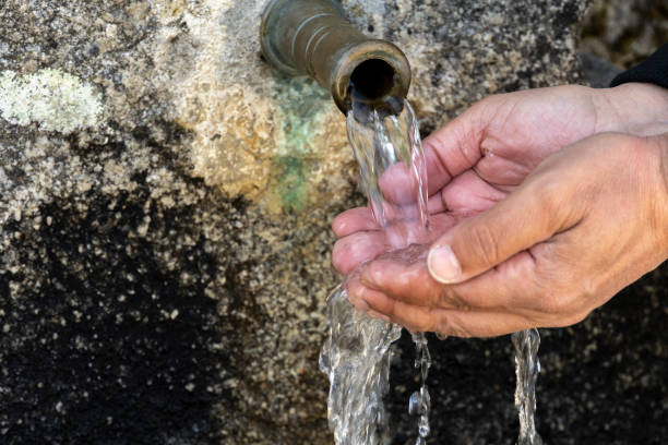 istock Hands of a man in an ancient fountain 2157172081