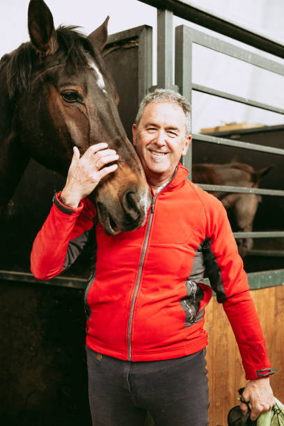 istock Retired man embracing his horse in stable 2157175599