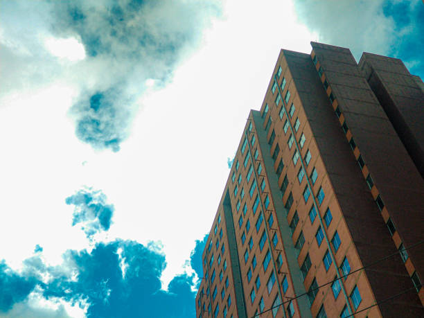 Blue sky with white clouds floating above city skyscrapers on a clear summer day.