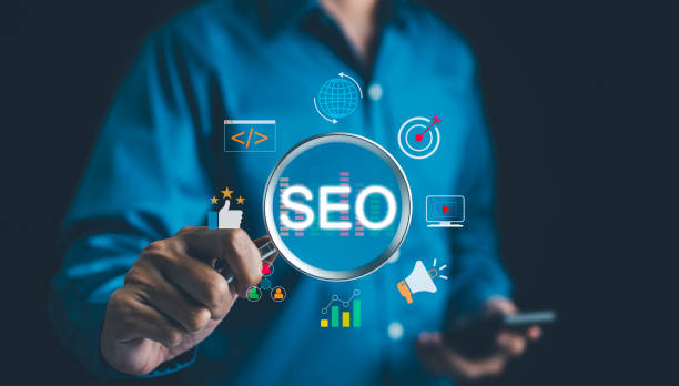 istock SEO Search Engine Optimization Concept. Businessman hold magnifying glass focuses highlighting SEO, surrounded by various digital marketing icons, representing search engine optimization strategies. 2157176274