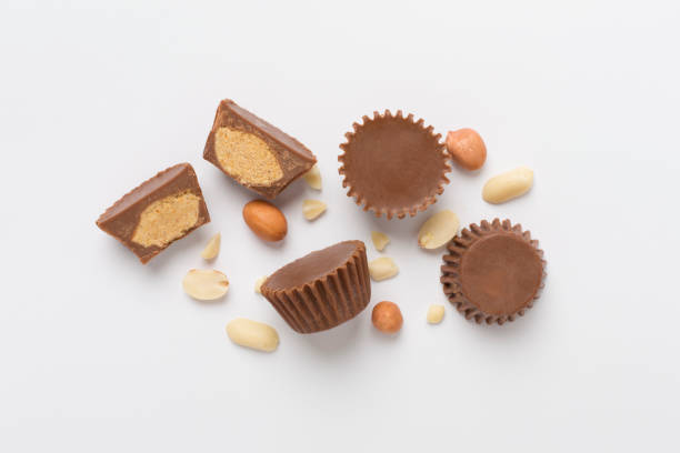 Tasty chocolate peanut butter cups on color background, top view