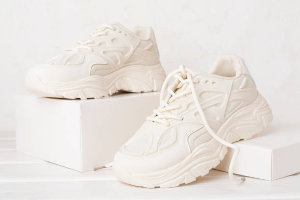 istock White woman trendy sneakers on concrete background 2157178141