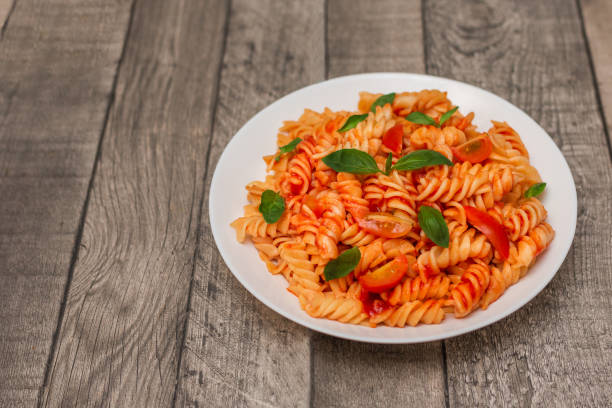 Italian pasta on plate on grey wooden background.
