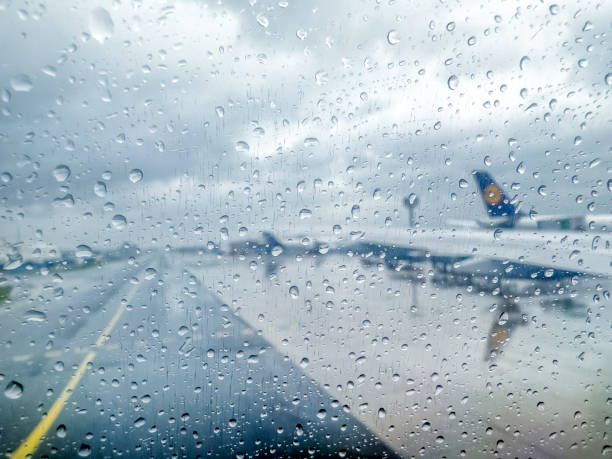 Storm at the airport. View of the airplane through rain drops. Waiting at the airport due to delay. Travel