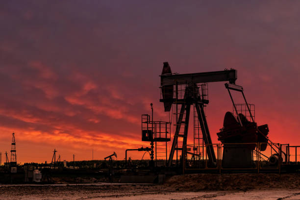 istock Oil drill rig silhouette and pump jack at sunset background. 2157181998