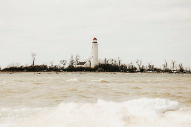 Very light snow falling on the 150 year old Old Mission Point Lighthouse with new shutters installed in 2020 that are representative of the shutters in place in the 1800s. Near Traverse City, Michigan