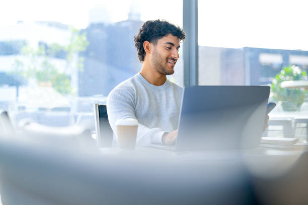istock Businessman working on a laptop computer and texting or using social media on a mobile phone in the office. 2157186184