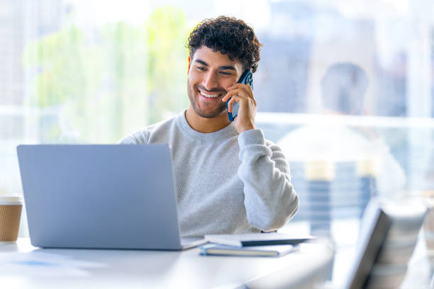 istock Businessman working on a laptop computer and talking on a mobile phone in the office. 2157186228
