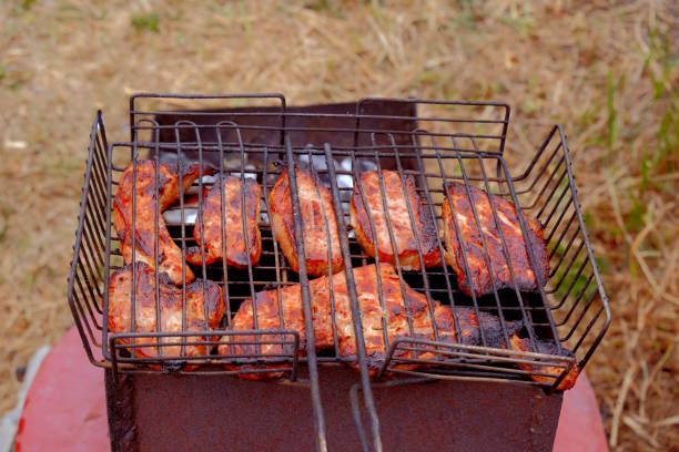 istock cooking steaks on coals on a barbecue grill in nature, top view... 2157191888