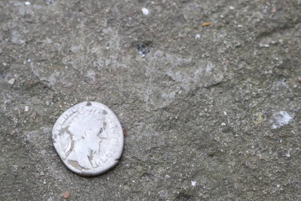 istock An ancient silver coin is placed on a worn and aged stone surface, reflecting history and heritage 2157192719