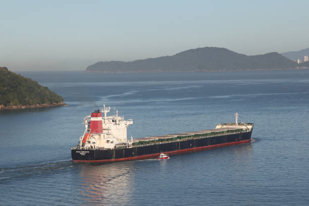 Image taken in Santos City from the main Port in Brazil of an empty cargo ship navigating the Santos Bay in a sunny day . The photograph underscores the significance of a cargo vessels in the main port of Brazil moving goods across the globe