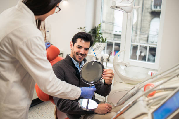 istock Smiling man looking in the mirror after a dental treatment 2157194820