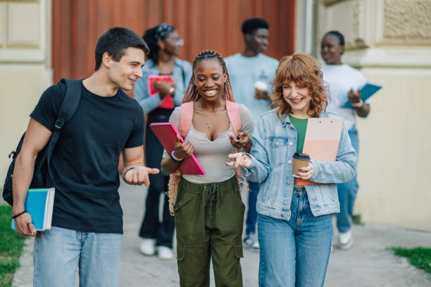 istock Diverse students near university building entrance walking towards camera 2157195203