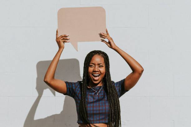 istock Cheerful black woman showing a blank speech bubble 2157195781