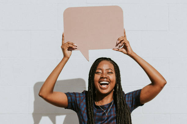 istock Cheerful black woman showing a blank speech bubble 2157195795