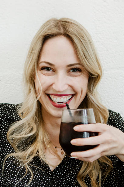 istock Happy woman sipping on a drink 2157196171