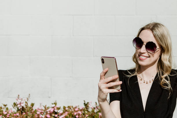 istock Cheerful woman with a sunglasses using her phone 2157196280