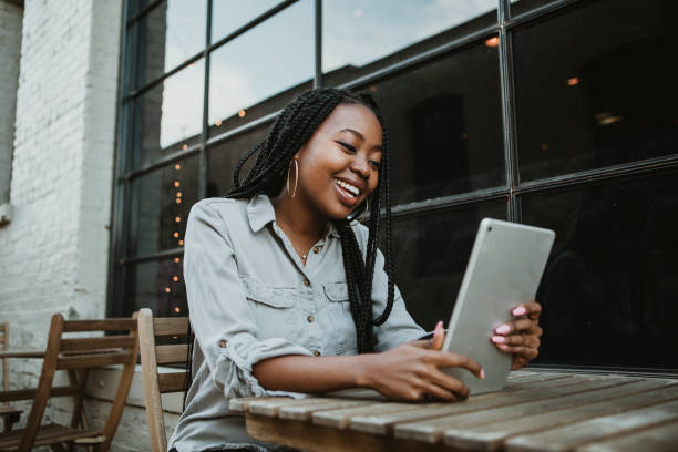 istock Black happy woman using a digital tablet outdoors 2157196383
