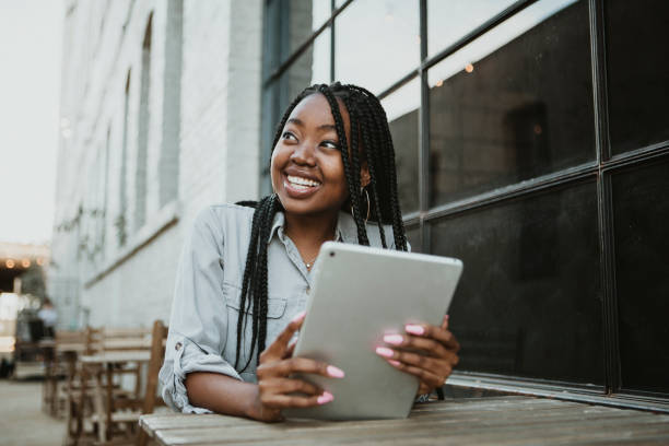 istock Black happy woman using a digital tablet outdoors 2157196384