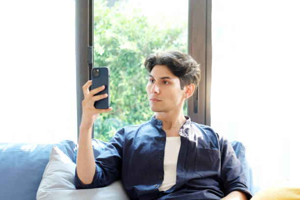 istock Young man scan his face for unlock his mobile phone, Face detection for verification on smart phone 2157200982