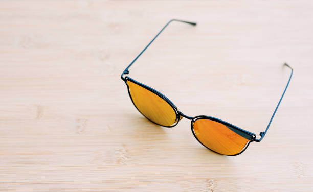 Orange mercury glasses reflect light top view close-up photo space copy space.