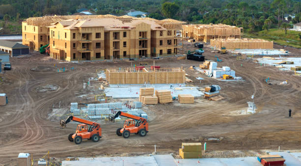 istock Unfinished frames of apartment condos with wooden roofs under construction. Development of residential housing in US suburbs. Real estate market in the USA 2157207392