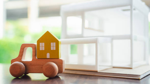 istock A car model carrying a stack of houses. Moving house concept. 2157207580