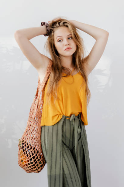 istock Blond girl holding a net bag with vegetables inside 2157214360