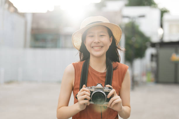 istock Smiling young asian female tourist with her camera 2157215577