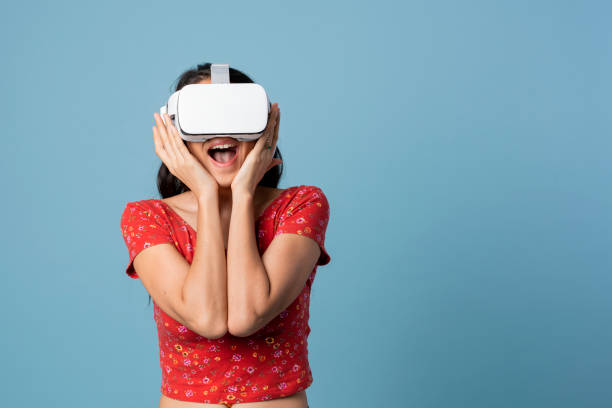 istock Woman having fun with a VR headset on blue background 2157215660