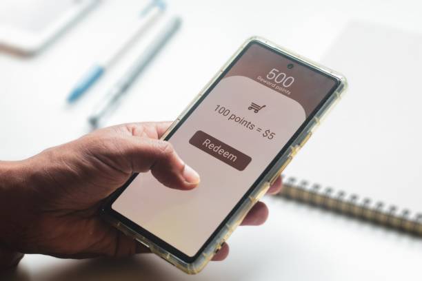 istock Man trying to transfer redeem rewards points into cash on his mobile phone. Loyalty programs to increase customer engagement in digital marketing concepts. Selective focus. 2157216853