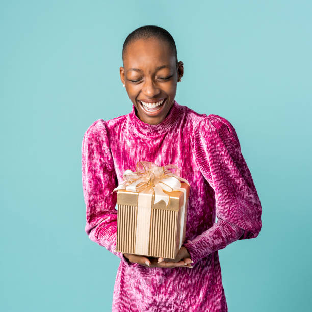 istock Happy black woman holding a gift box 2157218137