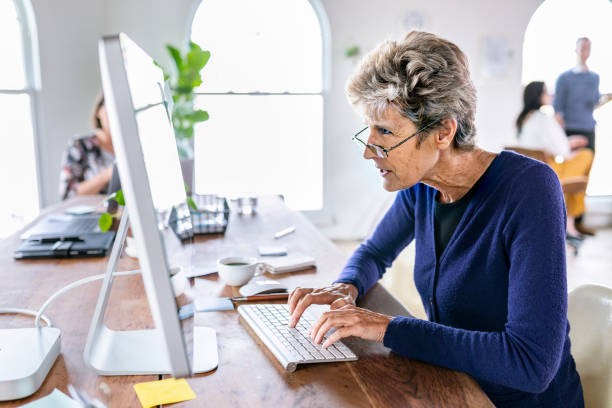 istock Senior woman typing on a computer keyboard 2157218575