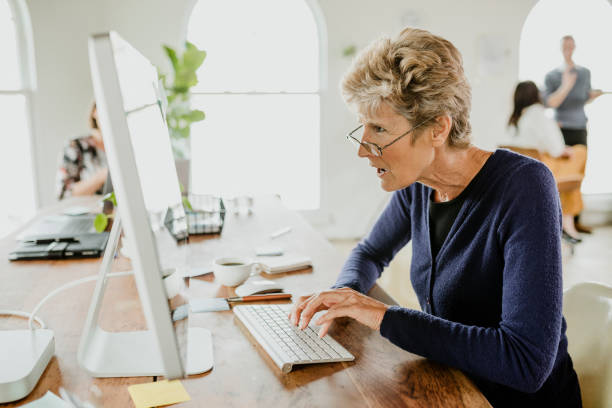istock Senior woman typing on a computer keyboard 2157218730