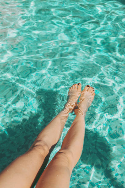istock Woman putting her legs in the pool 2157223227