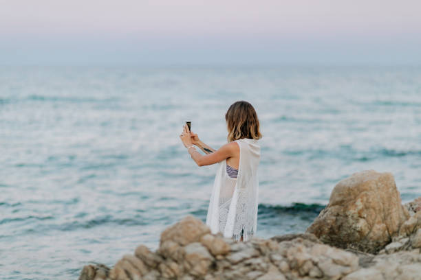 Woman taking a selfie at the rocky beach