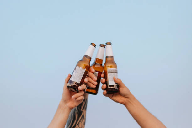 istock Guys having beers at the beach 2157223290