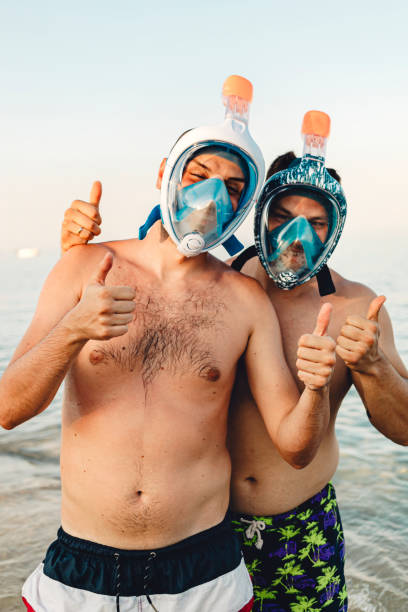 istock Men wearing full face snorkel mask standing at the beach 2157223311
