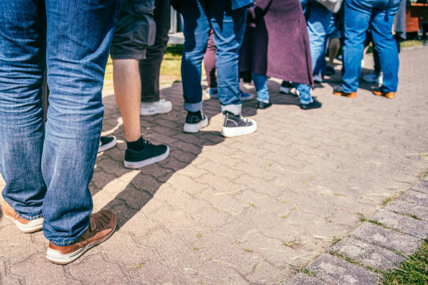 istock Long queue of people waiting in line 2157223379
