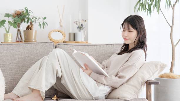 istock Woman reading a book on the sofa 2157225635