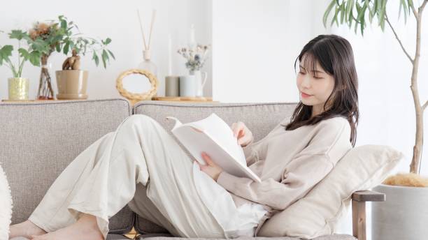 istock Woman reading a book on the sofa 2157225637