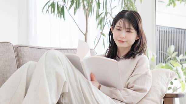 istock Woman reading a book on the sofa 2157225699
