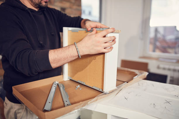 istock Man working and assembling furniture in a new apartment. 2157229663