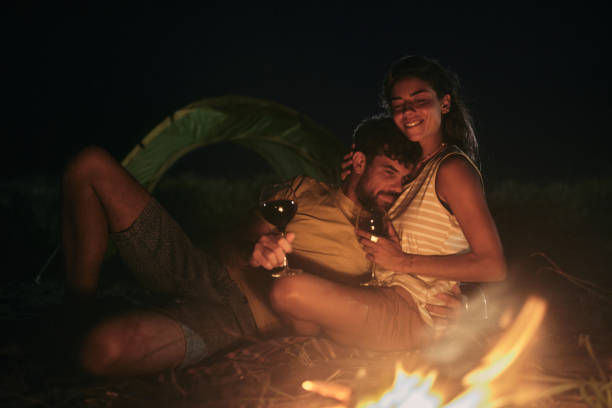 istock Loving couple drinking wine on camping night at the beach. 2157229750